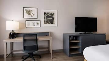 Une chambre d’hôtel équipée d’un bureau, d’une chaise, d’une télévision et d’un lit.