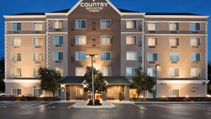 Un hotel de varios pisos con techo plano y un cartel que dice "Country Inn & Suites by Capison".
