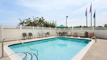 Una piscina al aire libre de temporada, sombrillas