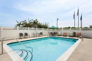 Una piscina al aire libre de temporada, sombrillas