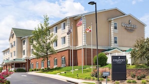 Un hôtel Country Inn & Suites à l’extérieur en briques, doté de nombreuses fenêtres et d’une enseigne indiquant l’entrée.