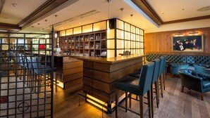 A bar area with a wooden counter, bar stools, and a seating area with upholstered chairs. - Best Western soibelmanns Lutherstadt Wittenberg (Lutherstadt Wittenberg)
