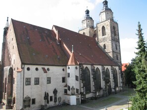 A historic building with a red-tiled roof, a bell tower, and a large arched window. - Best Western soibelmanns Lutherstadt Wittenberg (Lutherstadt Wittenberg)