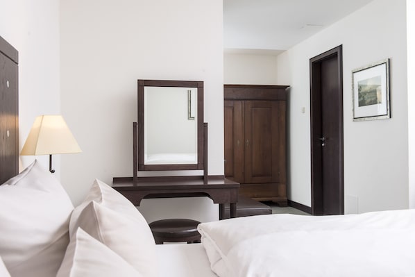 A hotel room with a bed, a desk with a mirror, a chair, a wardrobe, and a framed picture on the wall. - Best Western soibelmanns Lutherstadt Wittenberg (Lutherstadt Wittenberg)