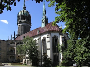 A historic church with a prominent tower and a spire, surrounded by trees. - Best Western soibelmanns Lutherstadt Wittenberg (Lutherstadt Wittenberg)