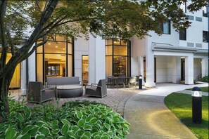 A modern building with large windows, outdoor seating, and a well-maintained garden. - Courtyard By Marriott Danbury (Danbury)
