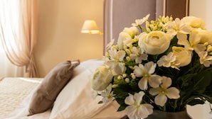 A hotel room with a bed, a nightstand, a lamp, and a vase with flowers. - Hotel Rosa dei Venti (Lerici)
