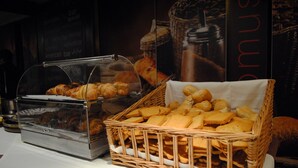 Une variété de pâtisseries et de pains présentés dans des paniers en osier sur une table.