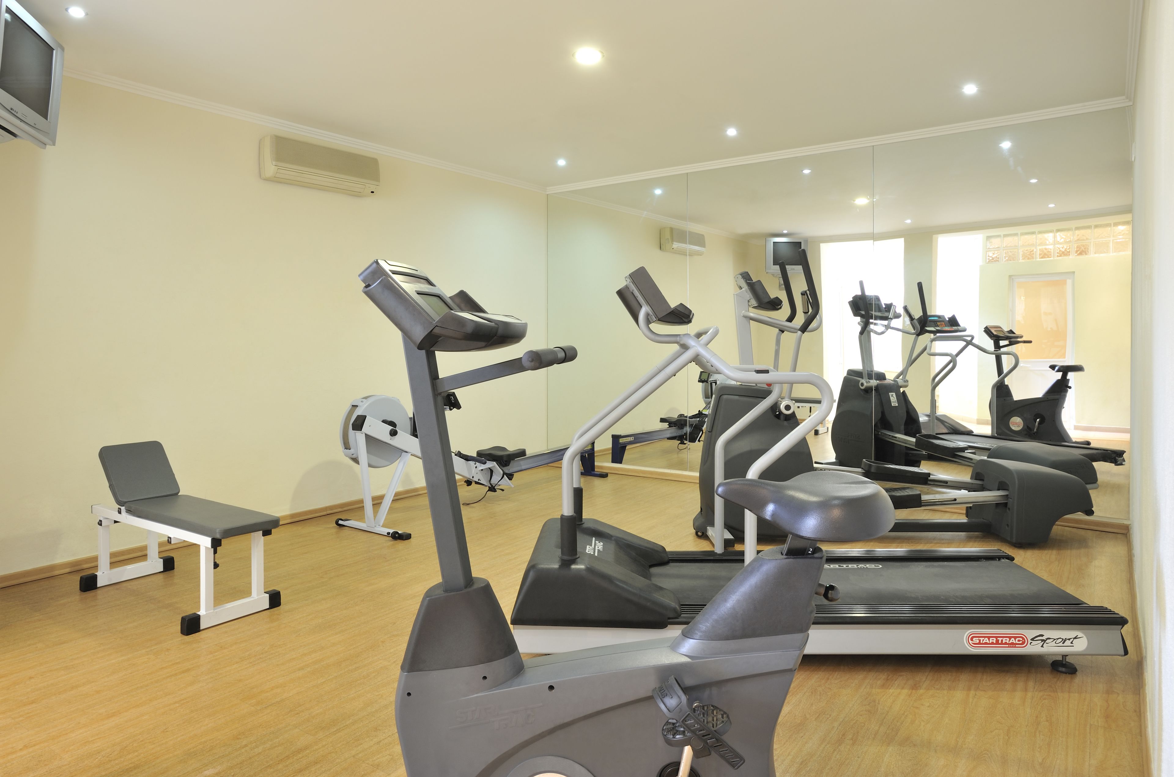 A gym with various exercise equipment, including treadmills and stationary bikes.
