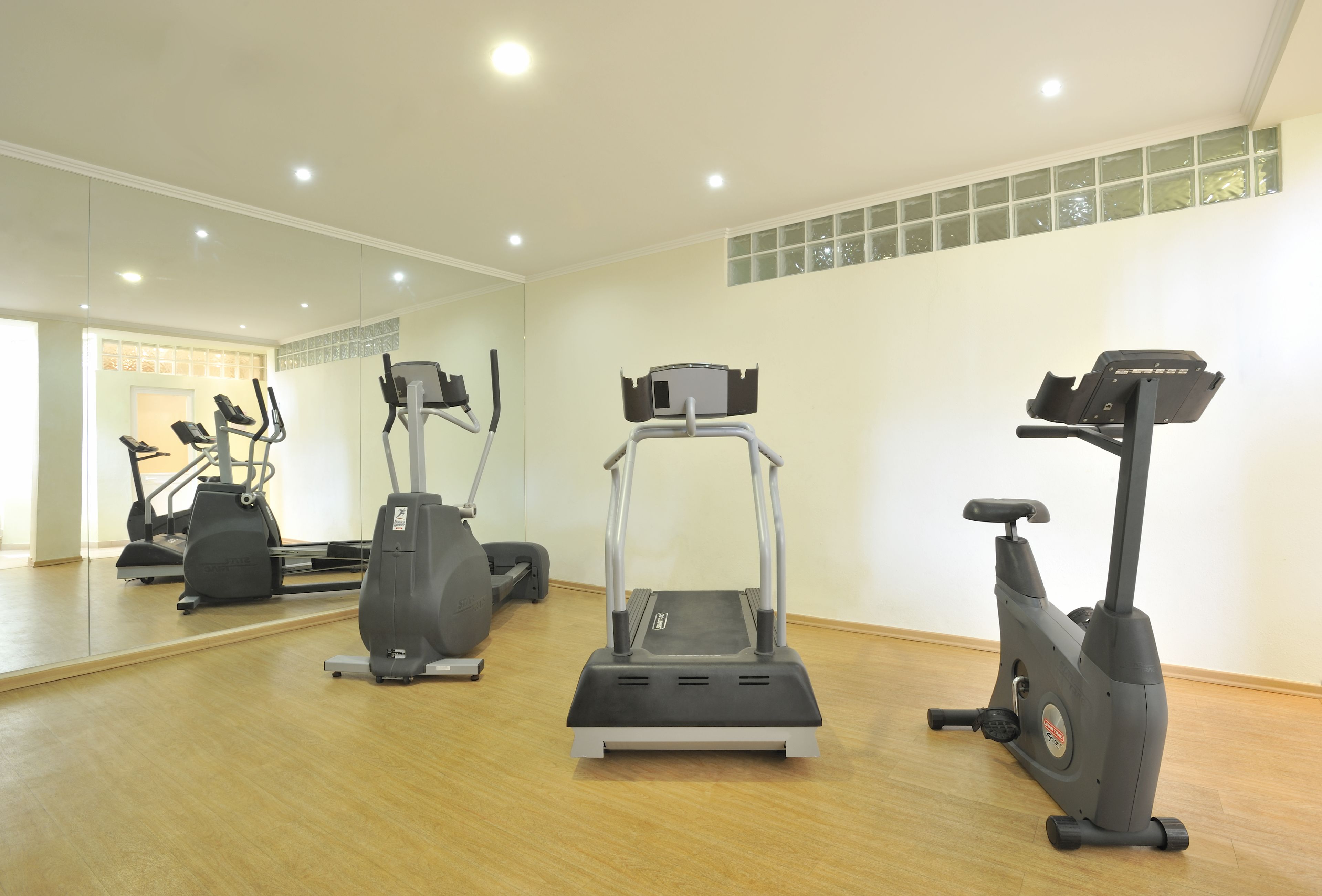 Une salle de sport équipée de tapis de course, d’appareils elliptiques et de vélos d’appartement.