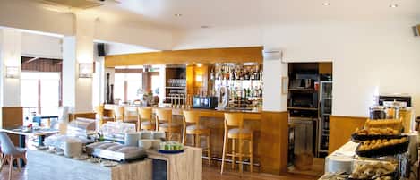 A buffet area with a variety of food items, a bar with a selection of beverages, and a seating area with chairs and tables.