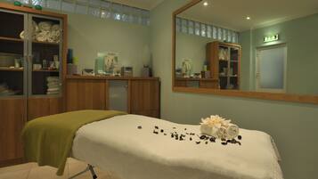 Relax in this serene space with a massage table, mirror, and ample storage.