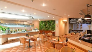 Un restaurant doté d'un espace buffet, de chaises en osier et d'un mur végétalisé.