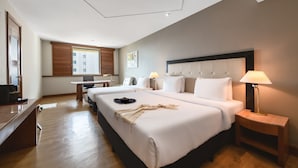 Une chambre d’hôtel avec deux lits, un bureau et une lampe.