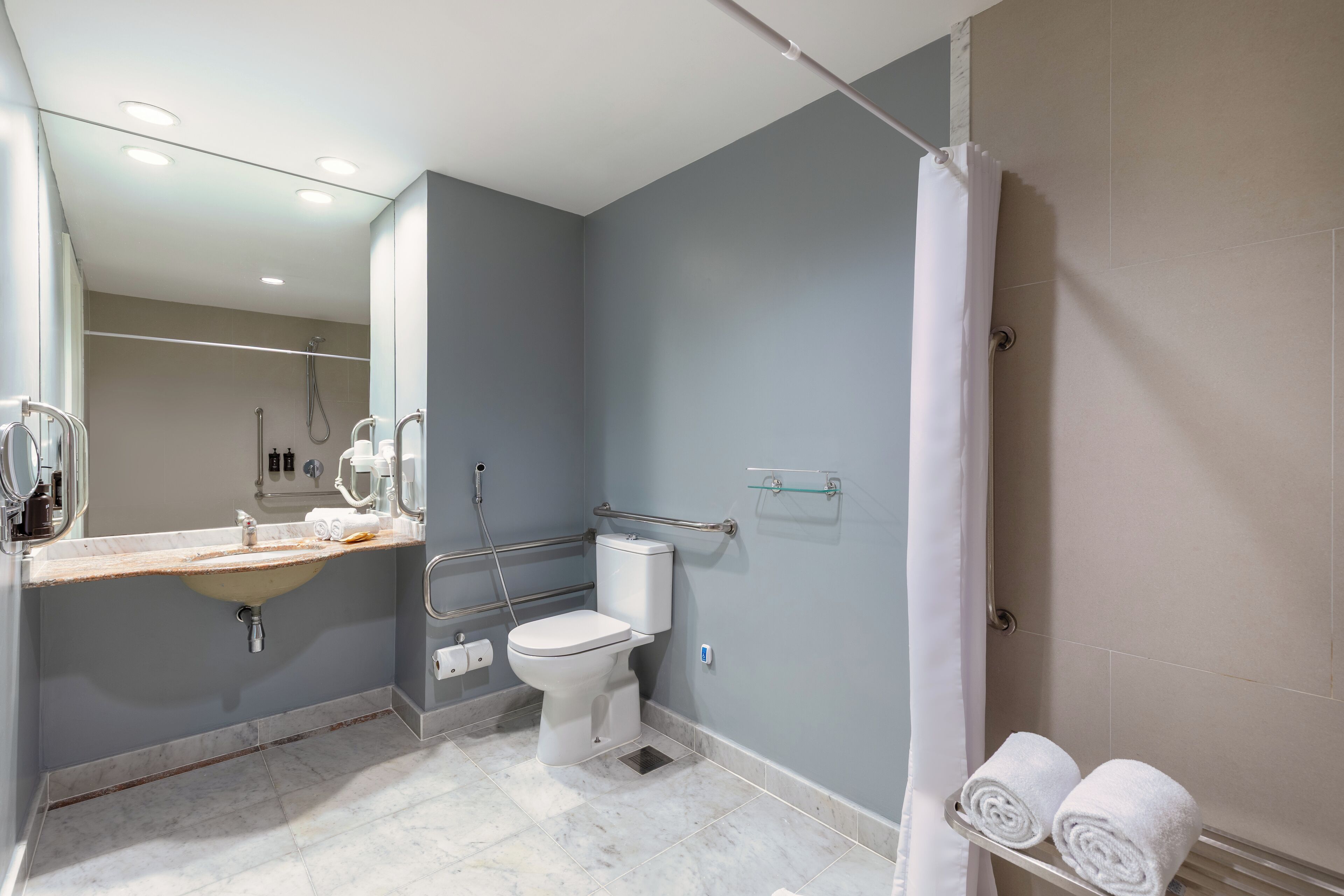 A modern bathroom with a sink, toilet, and shower.