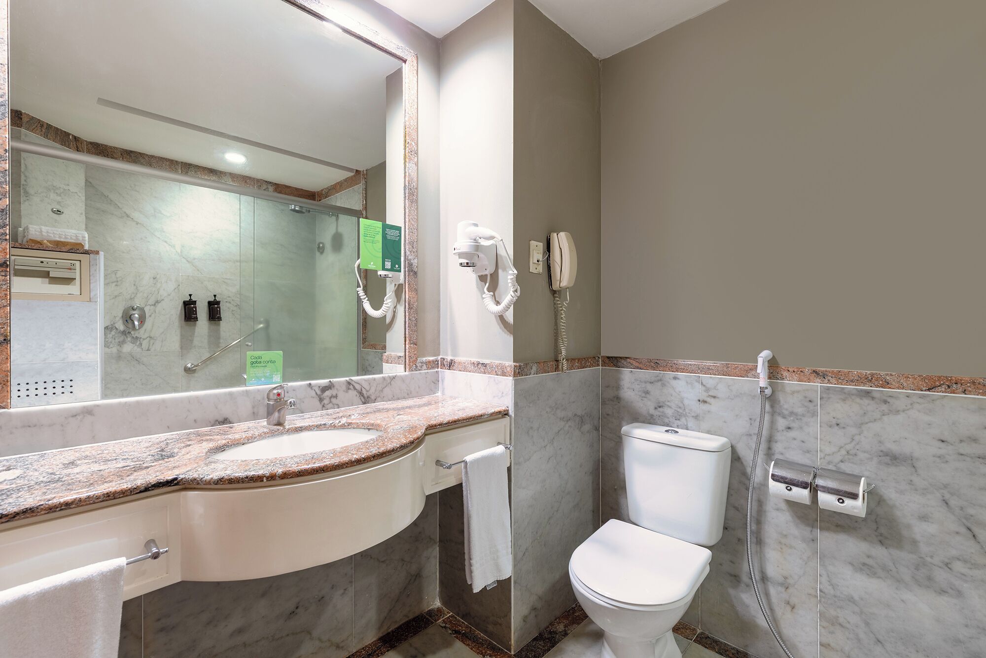Une salle de bain avec un lavabo en marbre, des toilettes et une douche.