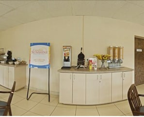 A reception area with a counter, a signboard, a coffee machine, and a vase with flowers. - Econo Lodge Smiths Falls (Smiths Falls)