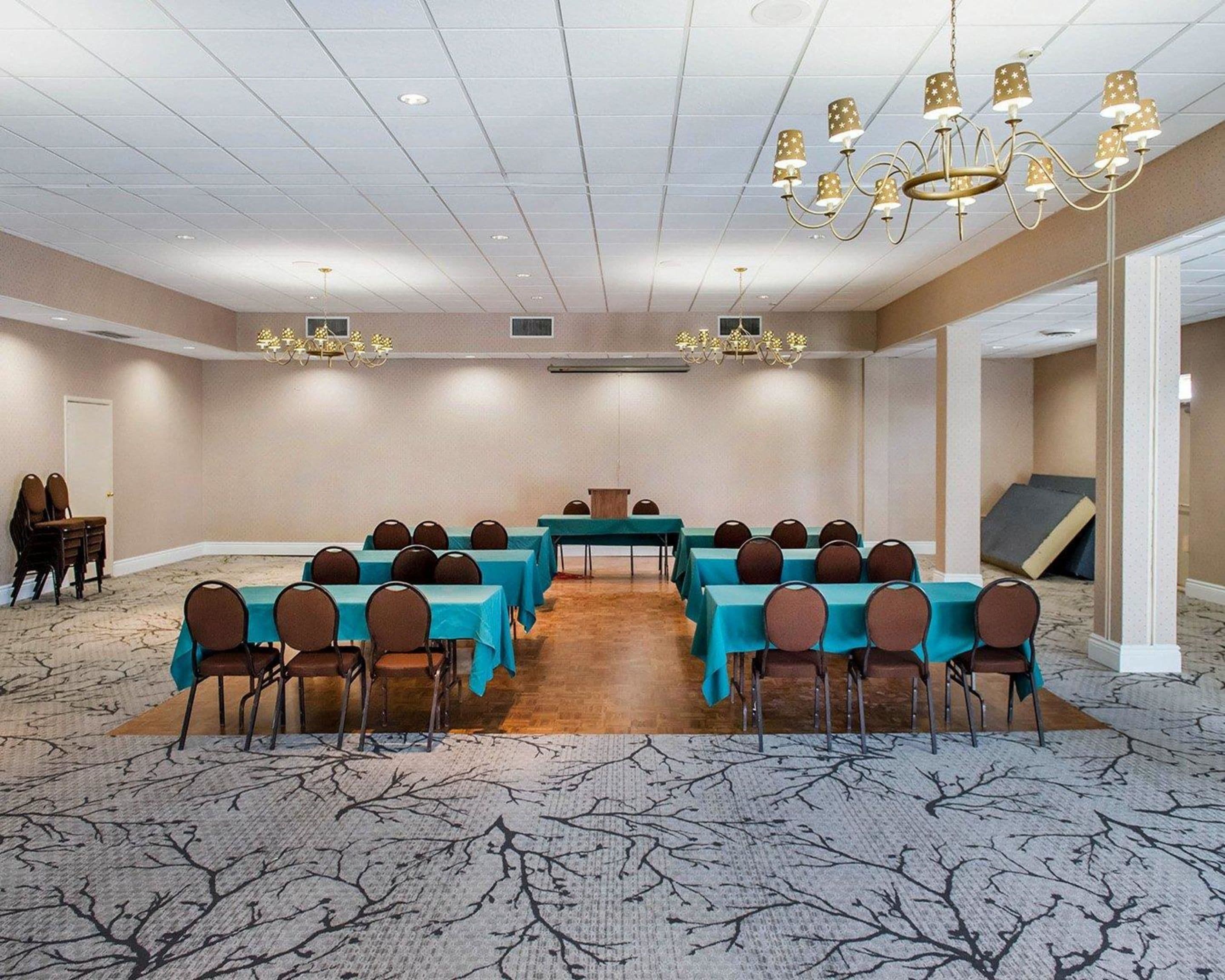Une salle de conférence avec une longue table, de nombreuses chaises et un lustre.