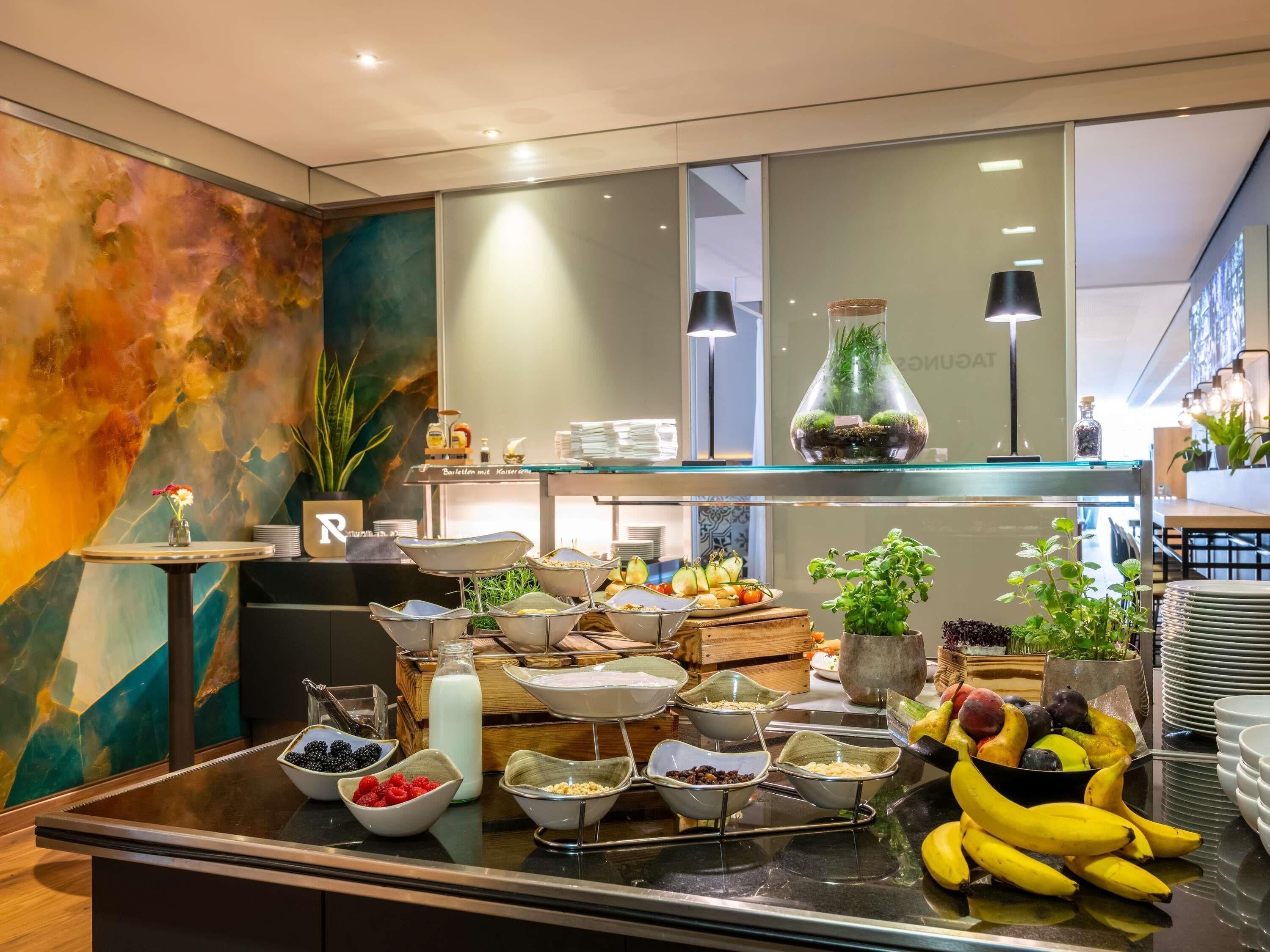 A buffet with various food items, a potted plant, and a decorative glass vase.