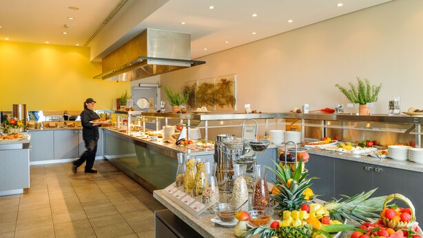 A buffet area with various food items and a person serving.