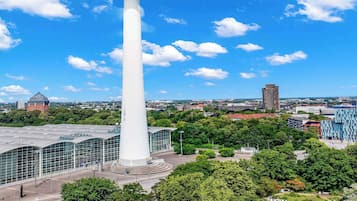 Surrounded by lush greenery and modern architecture, this tower offers a serene public space with pathways and benches.