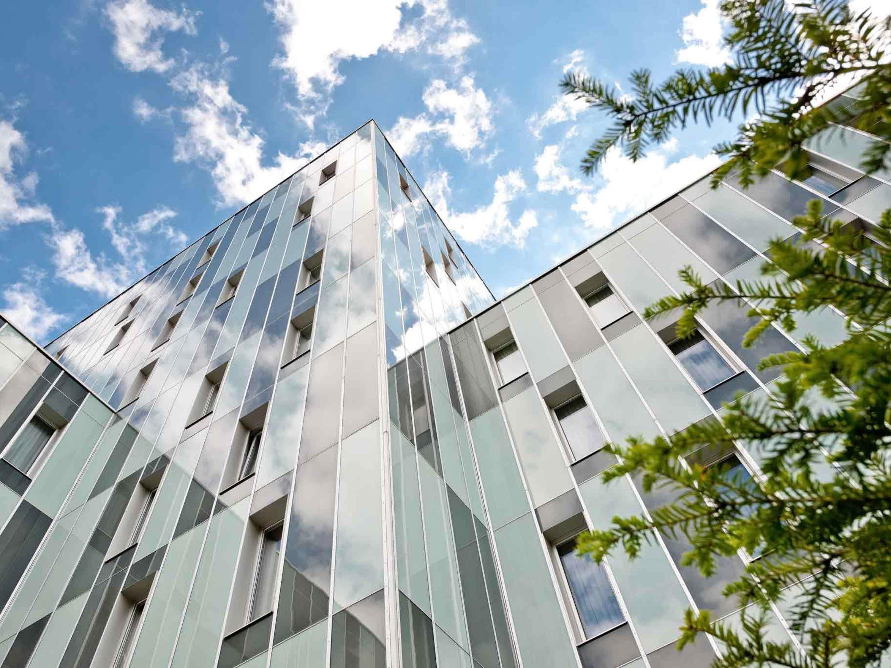Ein modernes Gebäude mit Glasfassade und blauem Himmel.
