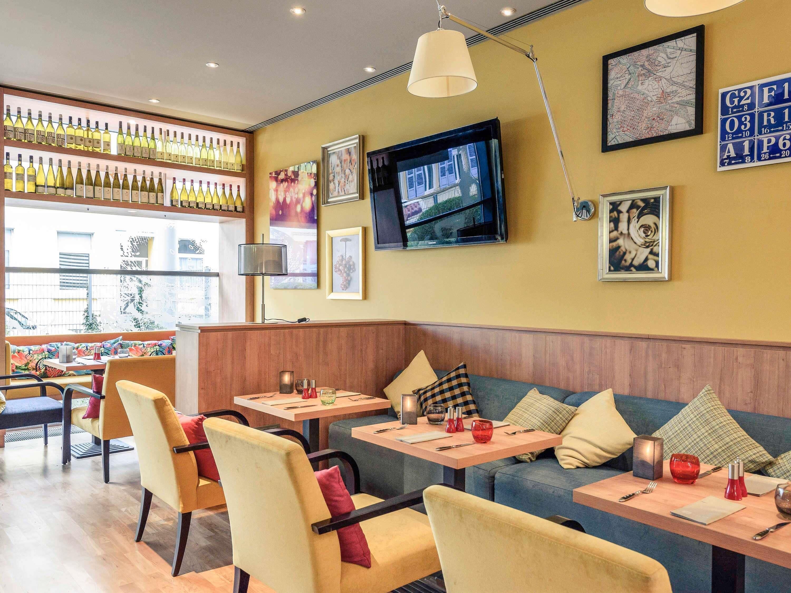 Un interior de restaurante con barra, zona de estar y televisor.