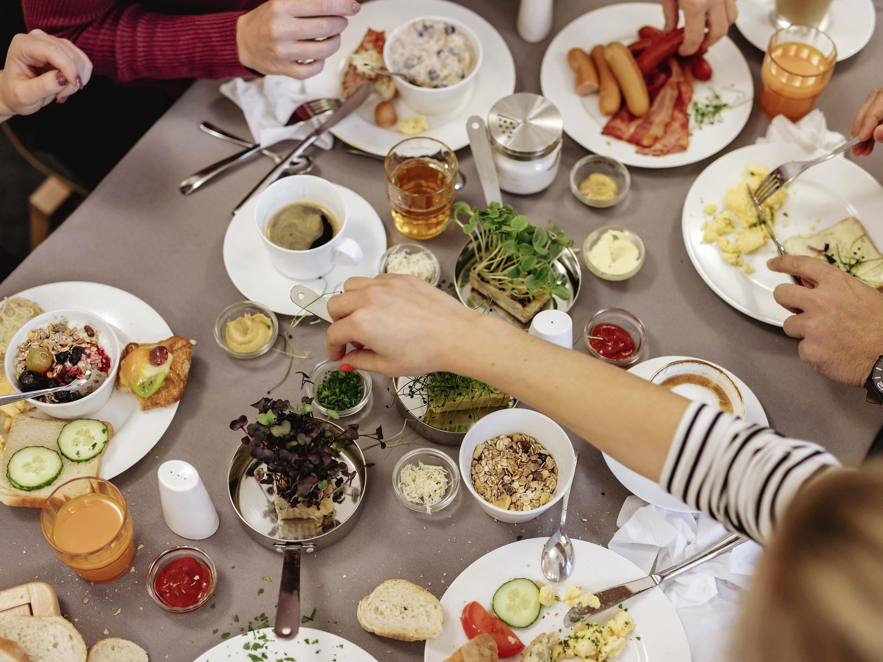A dining table with various food items and utensils, suggesting a meal setting.