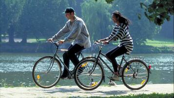 Dos personas andando en bicicleta por un sendero junto al agua.