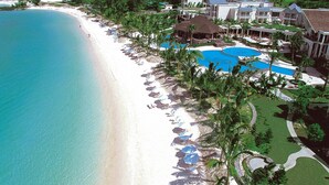 Un resort con playa, piscina y campo de golf.