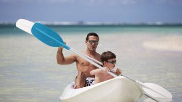 Un hombre y un niño en un barco pequeño sobre un mar tranquilo.