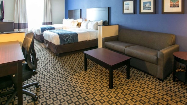 Une chambre d’hôtel avec un lit, un canapé, un bureau et une chaise.
