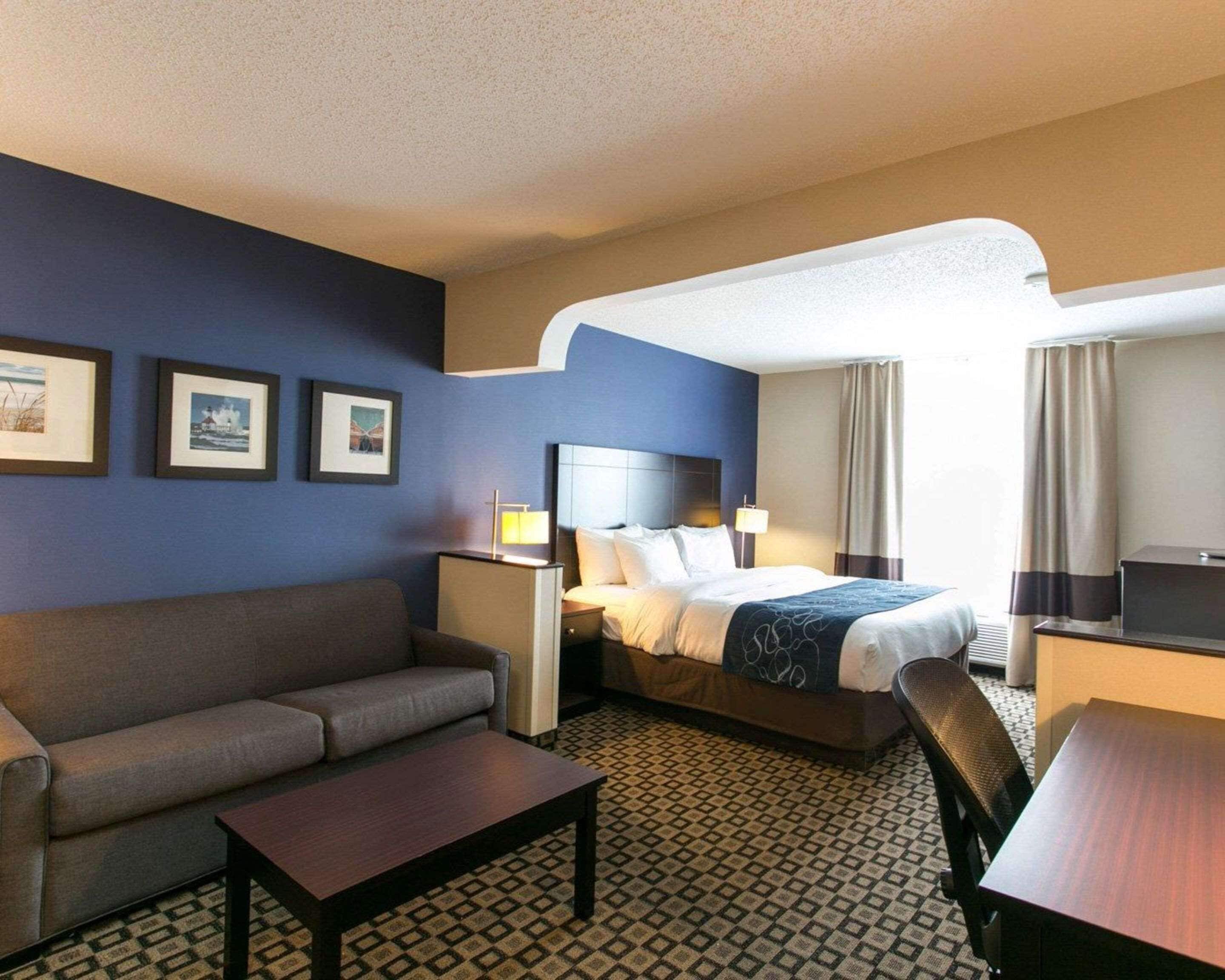 Een hotelkamer met een bed, een bank, een bureau en een televisie.