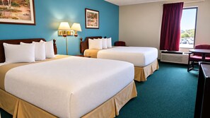 A hotel room with two beds, a desk, a chair, a lamp, and a window with curtains. - Days Inn by Wyndham Battlefield Rd/Hwy 65 (Springfield)