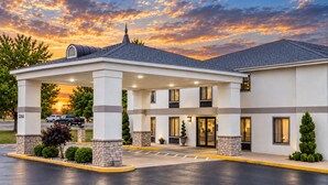 A hotel with a covered entrance, outdoor seating, and a parking area. - Days Inn by Wyndham Battlefield Rd/Hwy 65 (Springfield)