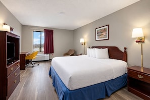 A hotel room with a large bed, a desk with a chair, a television, and a window with curtains. - Days Inn by Wyndham Battlefield Rd/Hwy 65 (Springfield)