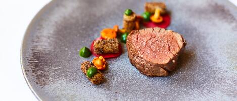 A plate with a piece of meat and various garnishes.