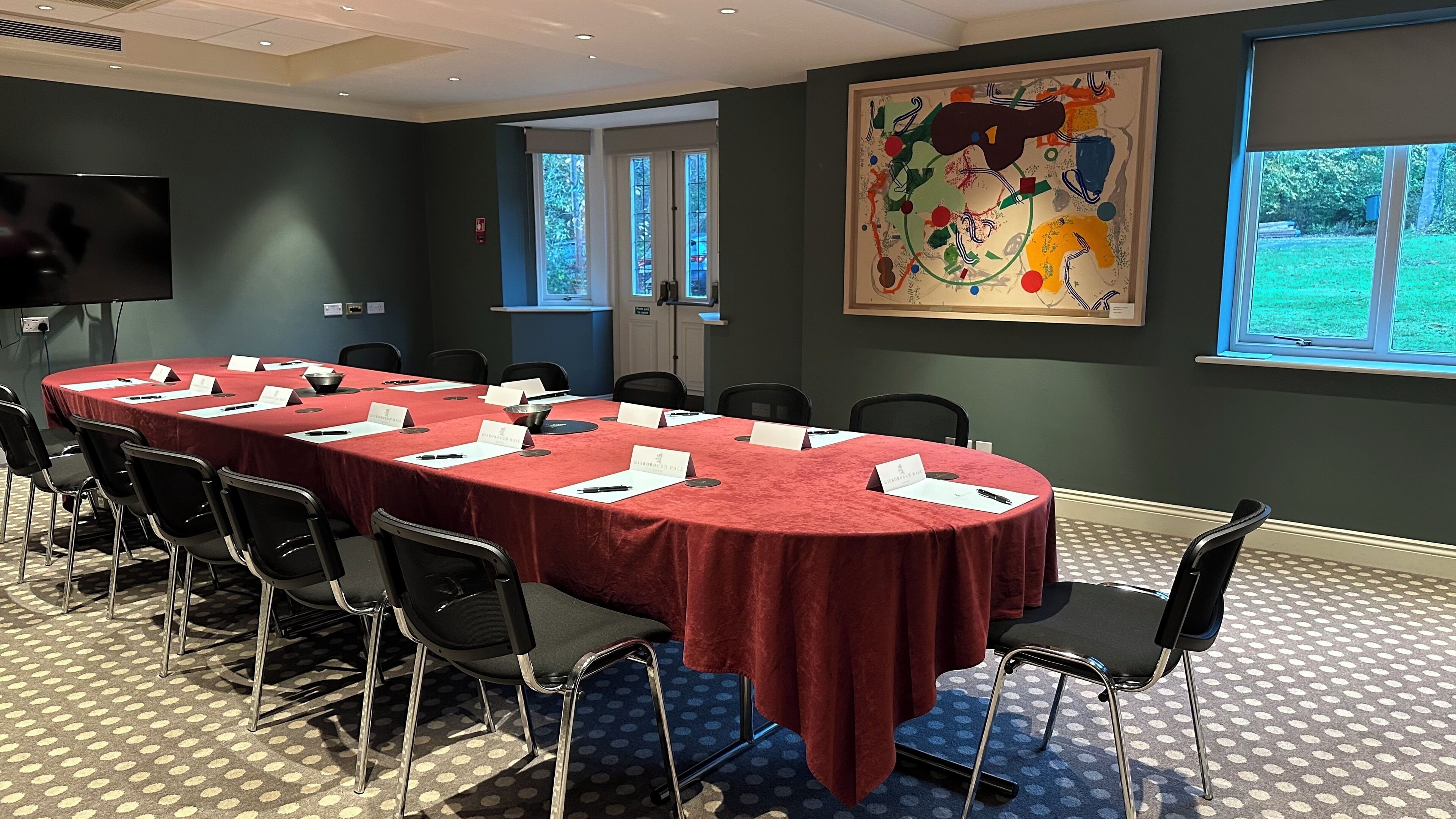 Uma sala de conferências com uma mesa comprida, cartões de nome e cadeiras.