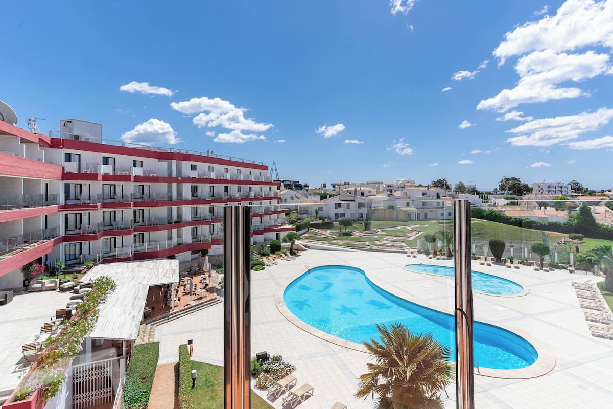 A hotel with multiple floors, outdoor swimming pools, and a landscaped courtyard.