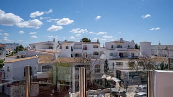 A coastal town with white buildings and terracotta roofs.