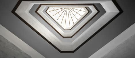 A geometric ceiling design with a central light fixture.