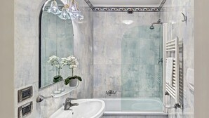 A bathroom with a bathtub, two sinks, a large mirror, and a shower enclosure. - Hotel Tre Archi (Venice)