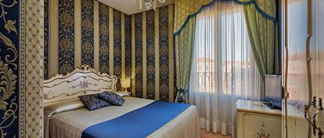 A bedroom with a large bed, a chandelier, a dresser, and curtains.