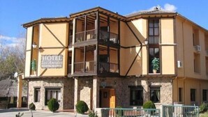 A hotel with a stone facade, multiple balconies, and a sign indicating it is a restaurant.