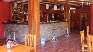 A bar area with a stone counter, wooden stools, and a tiled floor.
