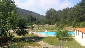 A residential area with a swimming pool, surrounded by trees and a hilly landscape. - Hotel Valle del Jerte Los Arenales (Jerte)