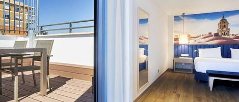 A hotel room with a bed, a nightstand, and a window with a view of a cityscape.