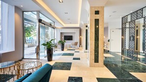 Un moderno vestíbulo de hotel con piso de cuadros, zona de estar y ventanas amplias.