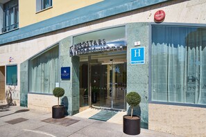 Welcome to the Eurostars Victoria Hotel, featuring a striking entrance with large glass windows and a prominent display of the hotel's name.