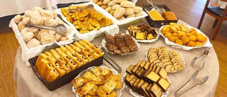 A buffet table with various baked goods and pastries.